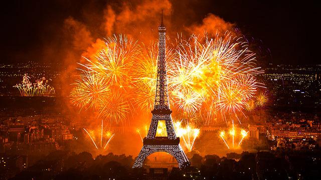 А опівночі небо   Парижа   розцвічується барвистими вогнями салюту